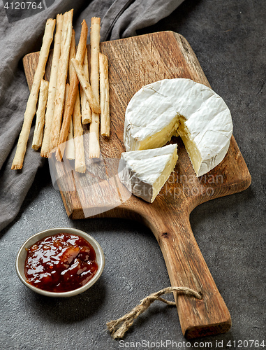 Image of camembert cheese on wooden cutting board