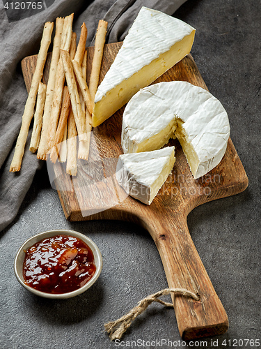 Image of camembert cheese on wooden cutting board