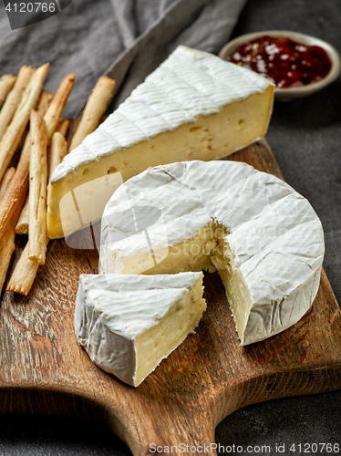 Image of camembert cheese on wooden cutting board