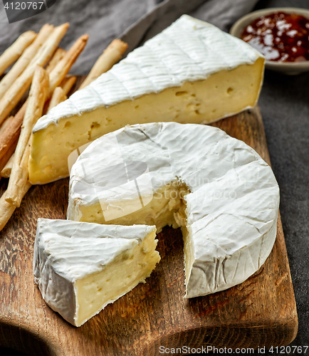 Image of camembert cheese on wooden cutting board