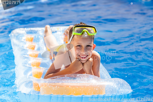 Image of Casual boy having fun in swimming pool