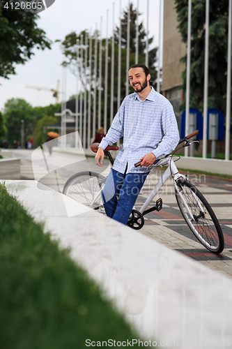 Image of young hipster man with fixed gear bike on city street