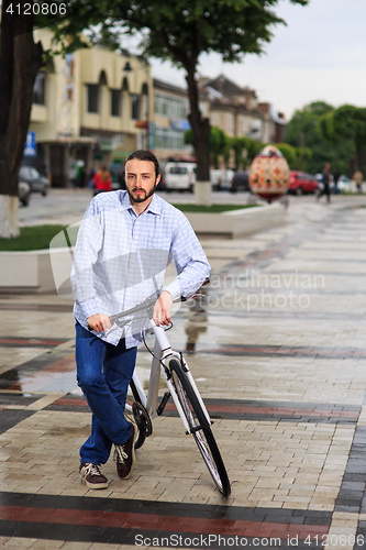 Image of young hipster man with fixed gear bike on city street