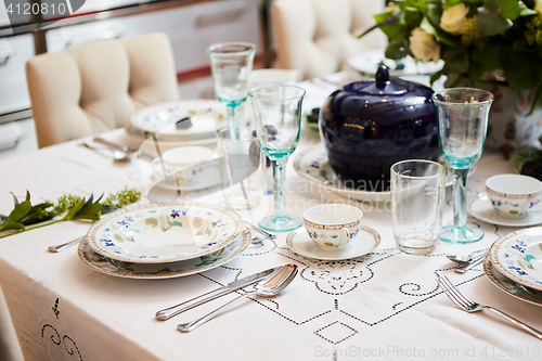 Image of Beautifully decorated table set with flowers, candles, plates and serviettes for wedding or another event in the restaurant.