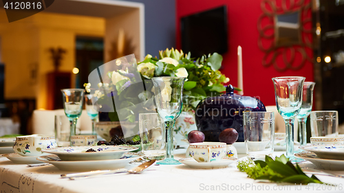 Image of Beautifully decorated table set with flowers, candles, plates and serviettes for wedding or another event in the restaurant.