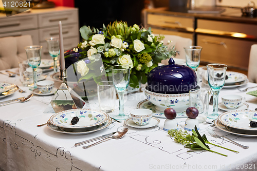 Image of Beautifully decorated table set with flowers, candles, plates and serviettes for wedding or another event in the restaurant.