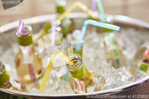 Image of bottles with tasty drink in ice. Shallow dof