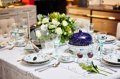 Image of Beautifully decorated table set with flowers, candles, plates and serviettes for wedding or another event in the restaurant.