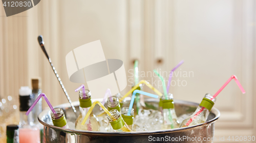 Image of bottles with tasty drink in ice. Shallow dof