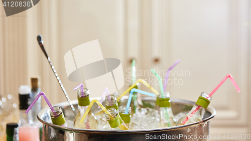 Image of bottles with tasty drink in ice. Shallow dof
