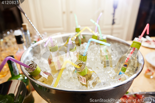 Image of bottles with tasty drink in ice. Shallow dof