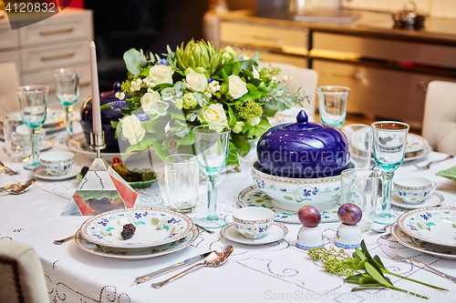 Image of Beautifully decorated table set with flowers, candles, plates and serviettes for wedding or another event in the restaurant.