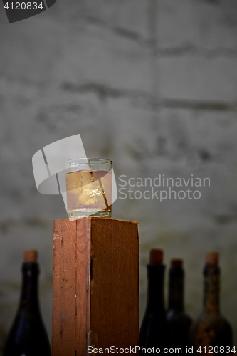 Image of Glass of whiskey with ice on old wooden bar