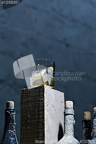 Image of Glass of whiskey with ice on old wooden bar