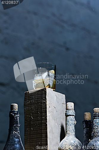 Image of Glass of whiskey with ice on old wooden bar