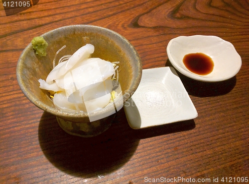 Image of Slices of japanese octopus in a bowl with salt and soy sauce