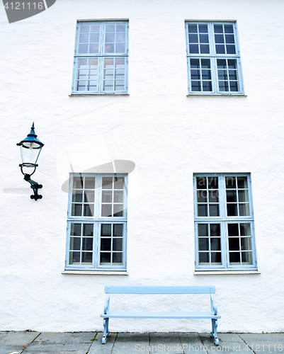 Image of Blue windows, a blue bench and a streetlight