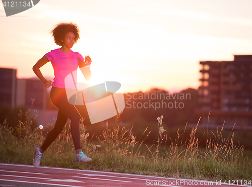 Image of a young African American woman jogging outdoors