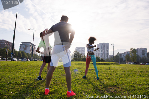Image of multiethnic group of people stretching in city park