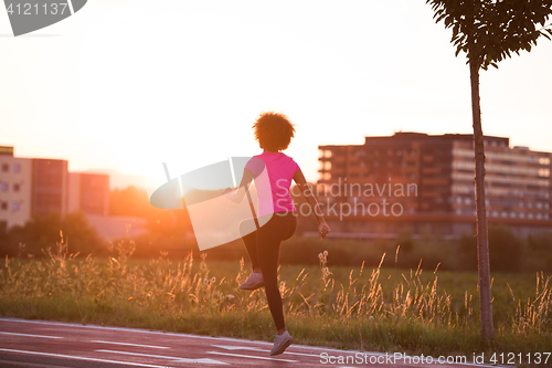 Image of a young African American woman jogging outdoors