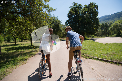 Image of Young  couple having joyful bike ride in nature