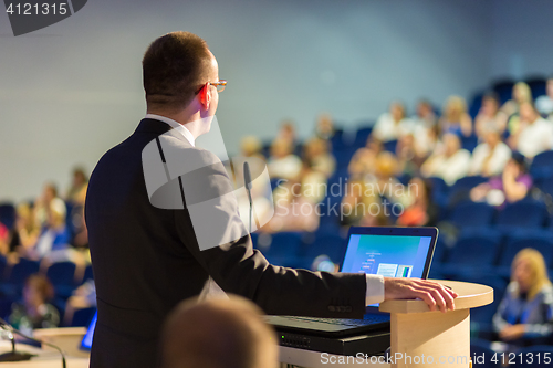 Image of Public speaker giving talk at business event.