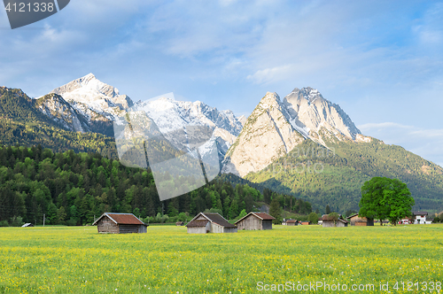 Image of Bavarian serene landscape with snowy Alps mountains and spring f