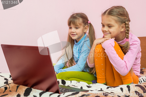 Image of Sisters looking at a laptop cartoon