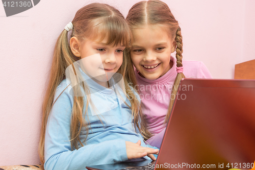 Image of Two girls playing in a notebook fun laughing