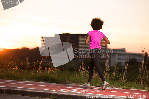 Image of a young African American woman jogging outdoors