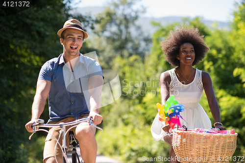 Image of Young  couple having joyful bike ride in nature