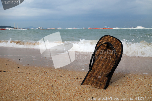 Image of Beach slippers on a sandy beach