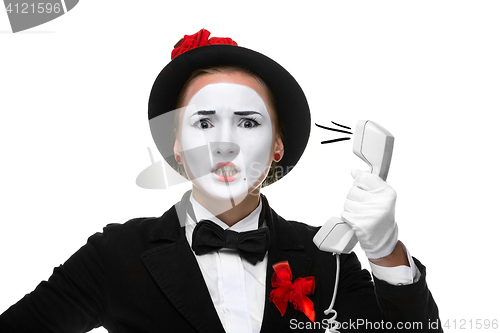 Image of Woman in the image mime holding a handset. 