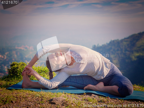 Image of Young sporty fit woman doing Hatha Yoga asana