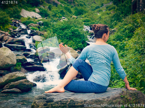 Image of Woman doing Ardha matsyendrasana asana outdoors