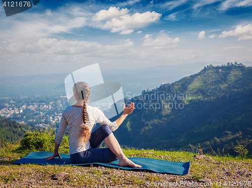 Image of Woman practices yoga asana outdoors