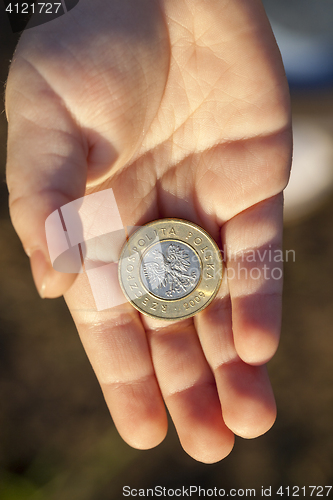 Image of coin in the hands of a child