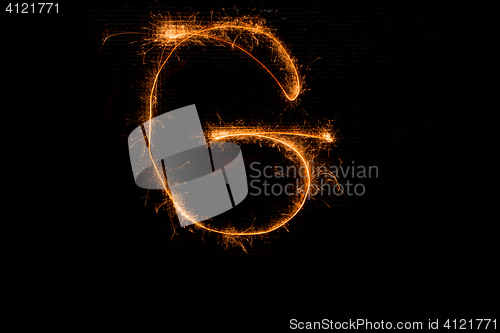 Image of Letter G made of sparklers on black