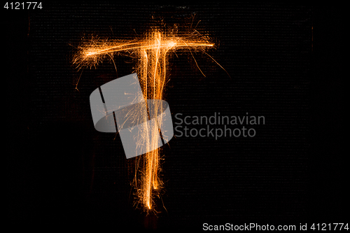 Image of Letter T made of sparklers on black