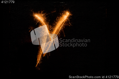 Image of Letter V made of sparklers on black