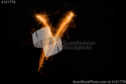 Image of Letter V made of sparklers on black