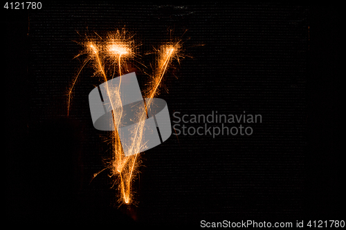 Image of Letter V made of sparklers on black