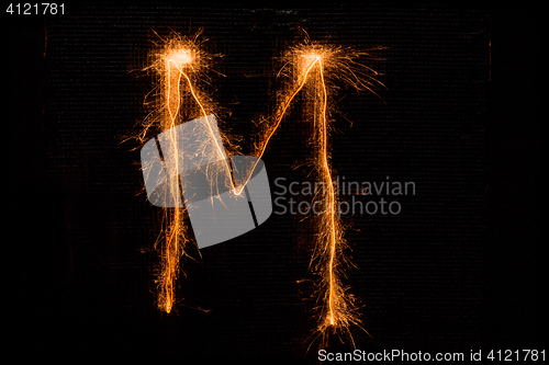 Image of Letter M made of sparklers on black