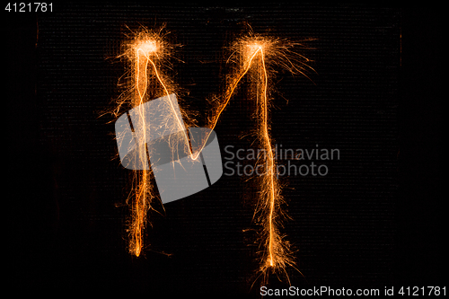 Image of Letter M made of sparklers on black