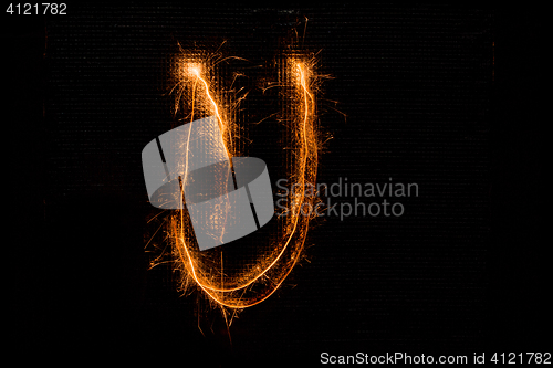 Image of Letter U made of sparklers on black