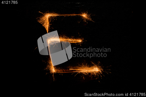 Image of Letter E made of sparklers on black