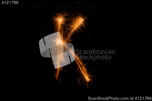 Image of Letter K made of sparklers on black