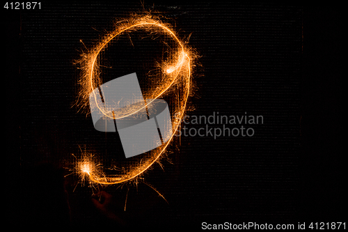 Image of Number 9 made of sparklers on black