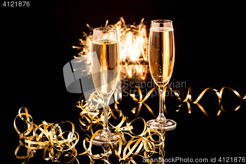 Image of Glasses with champagne against holiday lights