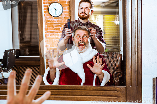 Image of Santa claus shaving his personal barber